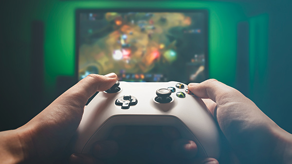 une personne tenant une manette xbox series x ou s et jouant à un jeu vidéo